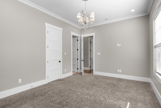 spare room featuring crown molding, an inviting chandelier, and carpet floors