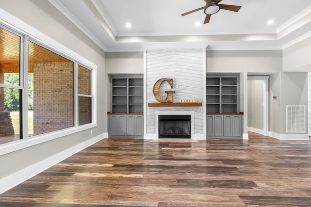 unfurnished living room featuring dark hardwood / wood-style flooring, ceiling fan, ornamental molding, and a fireplace