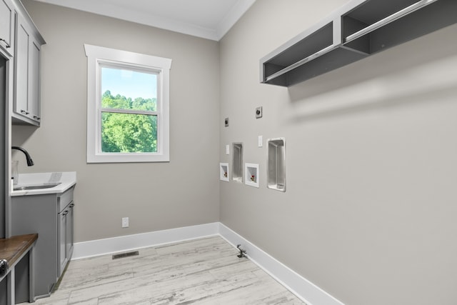 laundry room with gas dryer hookup, washer hookup, sink, electric dryer hookup, and light hardwood / wood-style flooring