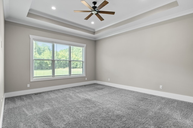 carpeted spare room with a tray ceiling, ceiling fan, and crown molding