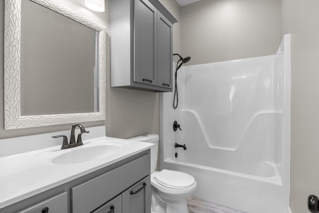 full bathroom featuring washtub / shower combination, hardwood / wood-style flooring, toilet, and vanity