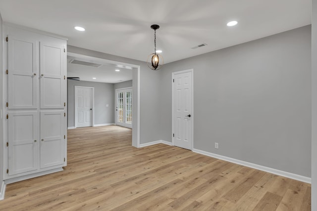 spare room with light hardwood / wood-style flooring and french doors