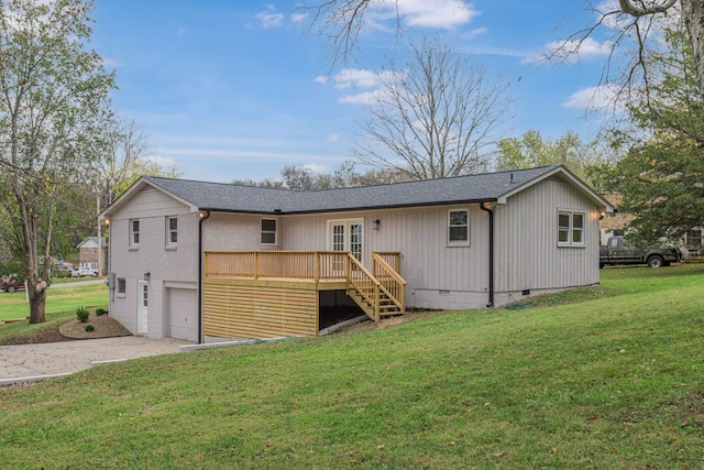 back of property featuring a lawn and a garage