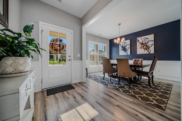 foyer entrance with hardwood / wood-style floors and an inviting chandelier