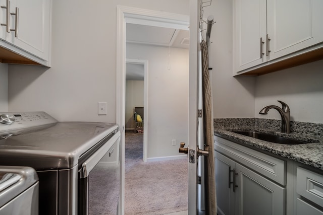 clothes washing area featuring cabinets, carpet, separate washer and dryer, and sink