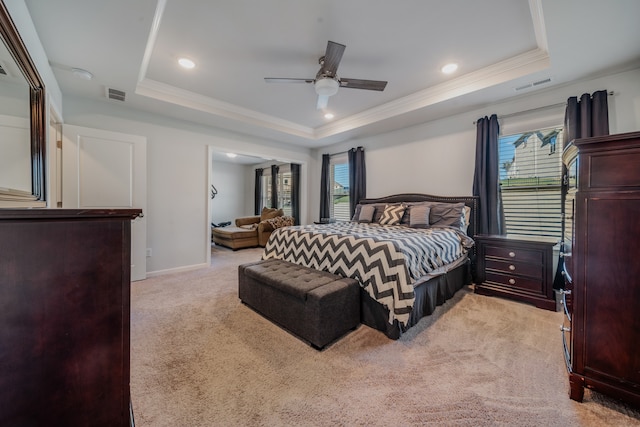 carpeted bedroom featuring a tray ceiling, multiple windows, and ceiling fan