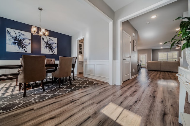 dining area featuring hardwood / wood-style floors and an inviting chandelier