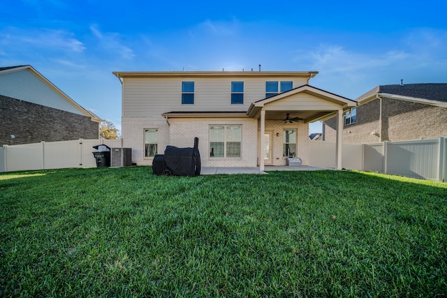 rear view of property with ceiling fan, a yard, and a patio