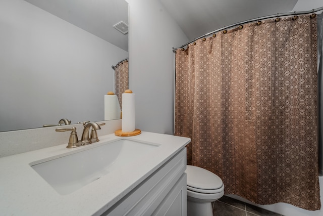 bathroom with toilet, vanity, and tile patterned floors