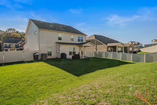 rear view of property featuring a yard and central air condition unit