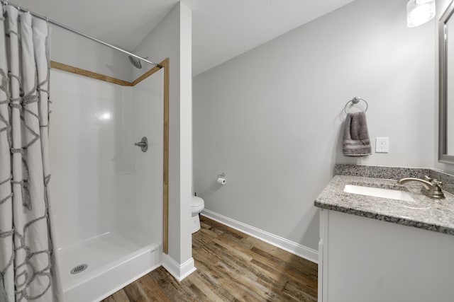 bathroom featuring a shower with curtain, hardwood / wood-style flooring, vanity, and toilet