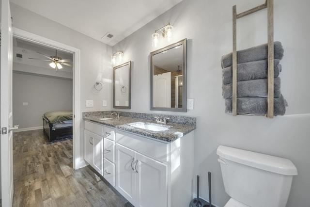 bathroom with toilet, vanity, wood-type flooring, and ceiling fan