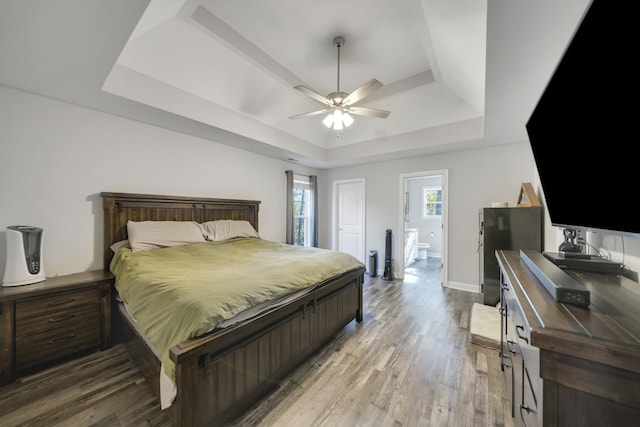 bedroom with hardwood / wood-style flooring, ceiling fan, and a tray ceiling