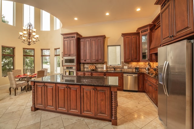 kitchen with a center island, sink, ornamental molding, and stainless steel appliances