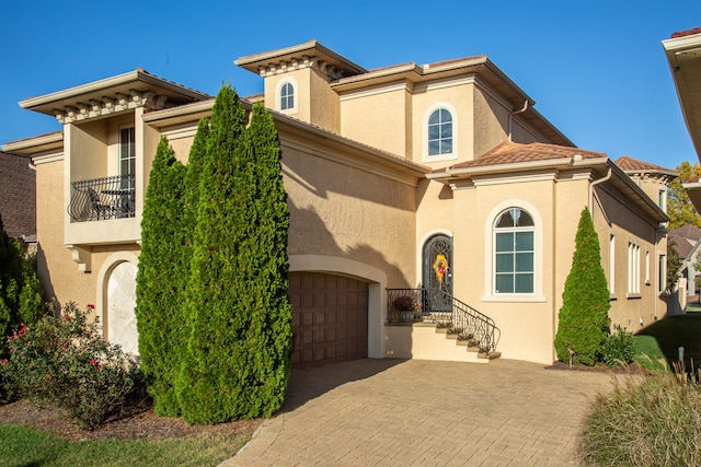 mediterranean / spanish-style house featuring a garage and a balcony