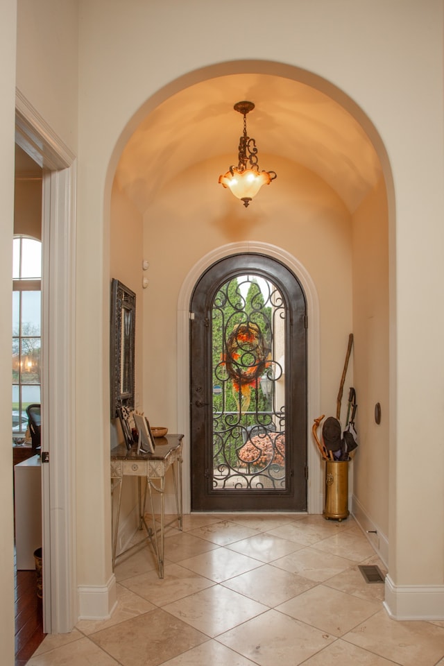 tiled foyer entrance featuring vaulted ceiling