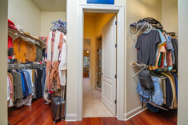 walk in closet with hardwood / wood-style flooring