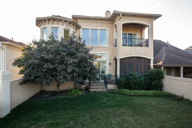 view of front of home featuring a balcony and a front yard