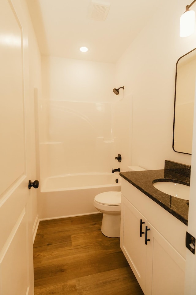 full bathroom featuring shower / bathing tub combination, vanity, wood-type flooring, and toilet