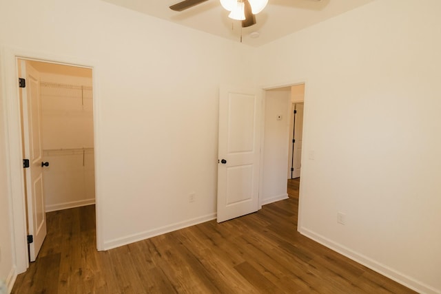 empty room with ceiling fan and dark wood-type flooring