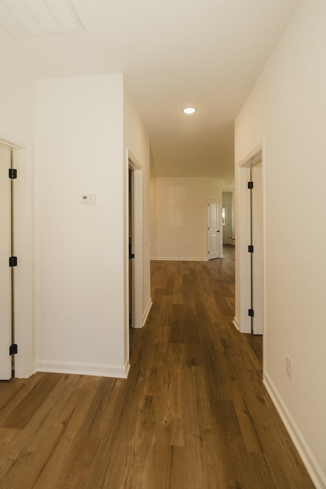 corridor with dark hardwood / wood-style flooring