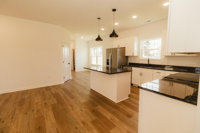 kitchen with hardwood / wood-style floors, a center island, white cabinets, stainless steel refrigerator with ice dispenser, and hanging light fixtures