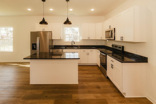 kitchen with sink, hanging light fixtures, dark hardwood / wood-style floors, white cabinets, and appliances with stainless steel finishes