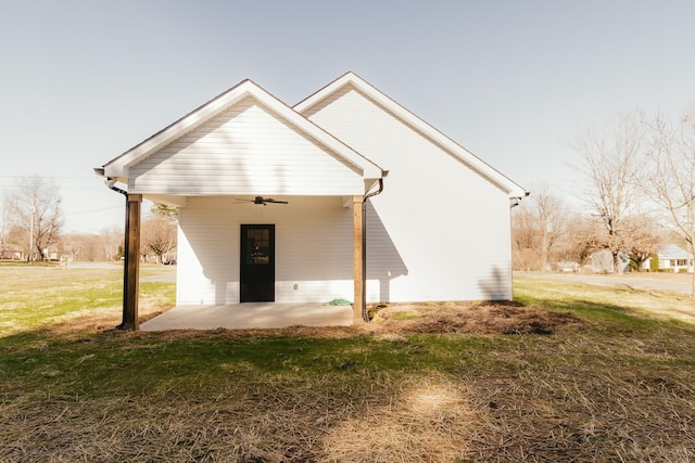 back of property featuring a lawn and ceiling fan