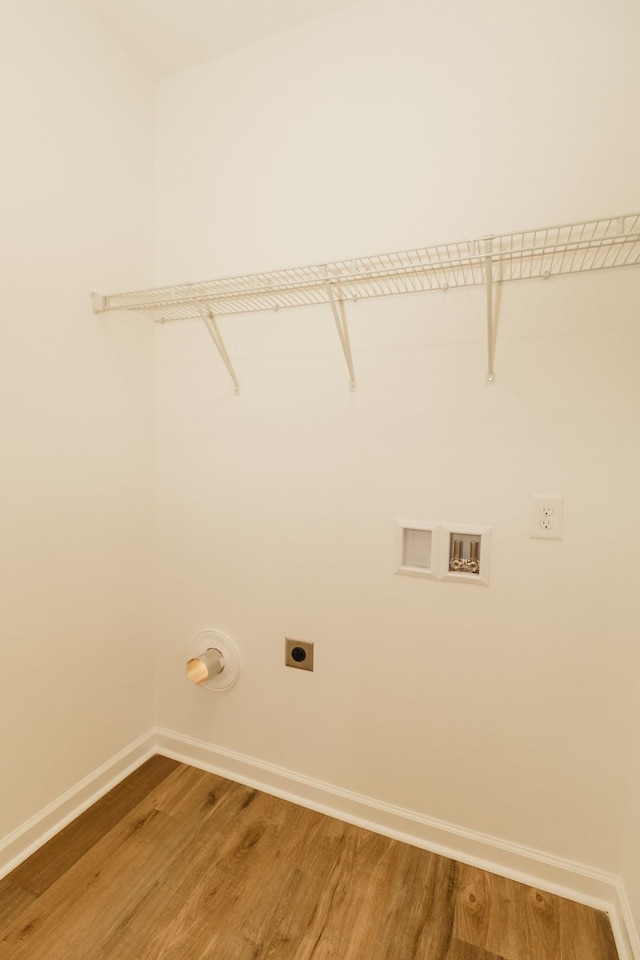 clothes washing area with electric dryer hookup, hardwood / wood-style floors, and washer hookup