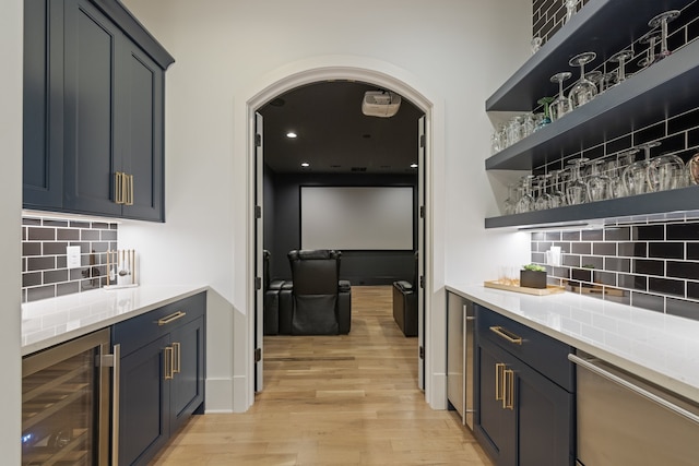 bar featuring backsplash, beverage cooler, light wood-type flooring, and dishwasher