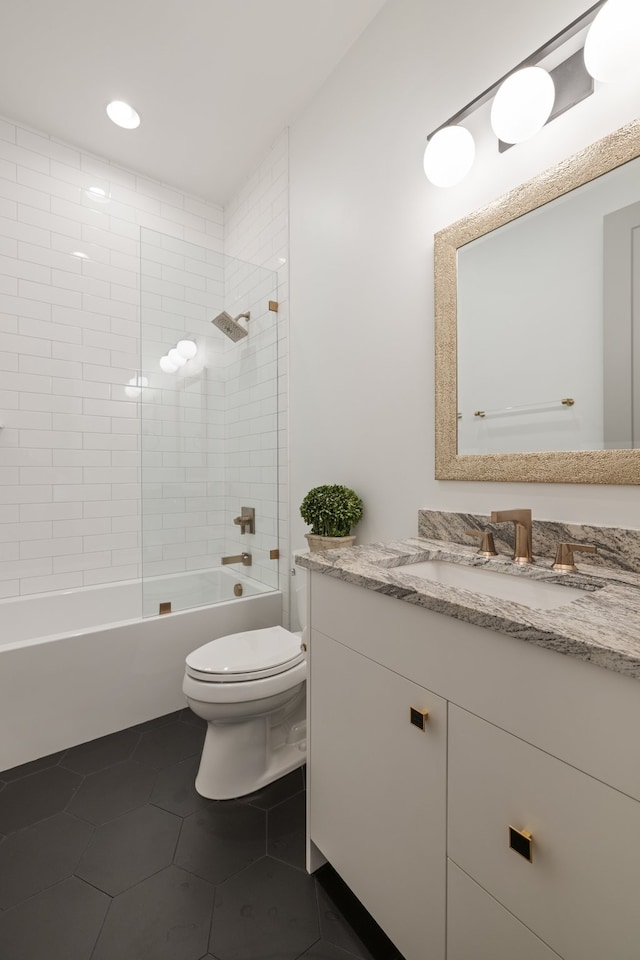 full bathroom featuring tile patterned flooring, vanity, toilet, and tiled shower / bath