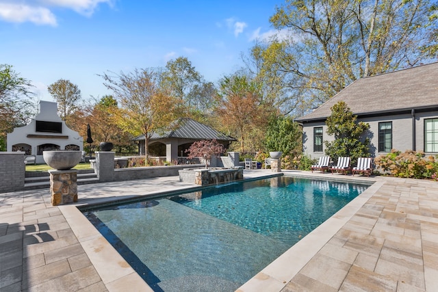 view of swimming pool with an outdoor fireplace and a patio area