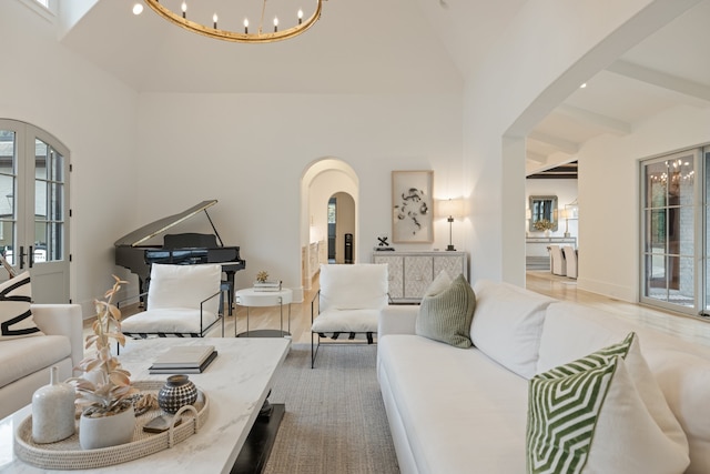 living room featuring high vaulted ceiling, light hardwood / wood-style floors, and a notable chandelier