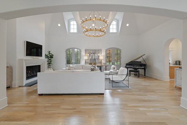 living room featuring high vaulted ceiling, a wealth of natural light, and light hardwood / wood-style flooring