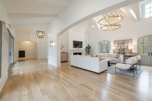 living room with high vaulted ceiling, light hardwood / wood-style floors, and a healthy amount of sunlight