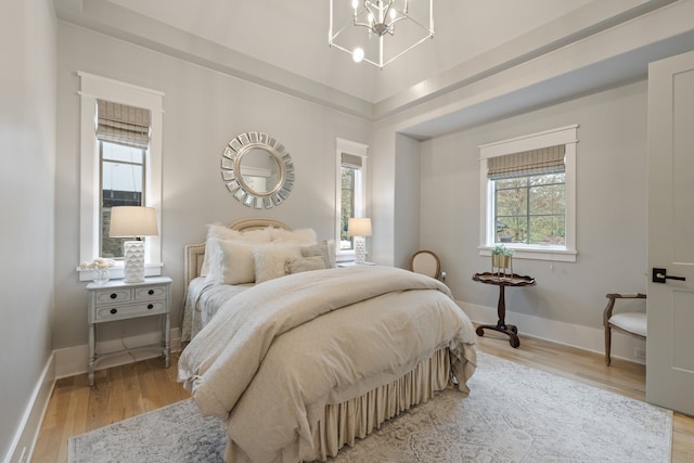 bedroom featuring light wood-type flooring and a notable chandelier