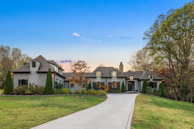 french country inspired facade with a yard