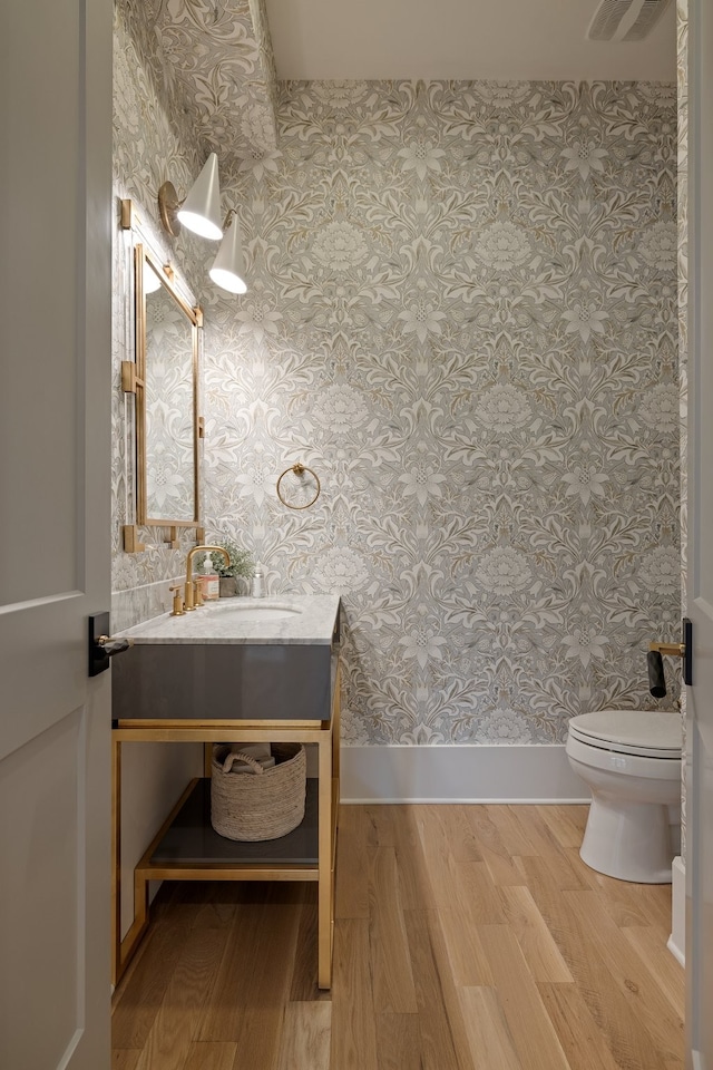 bathroom featuring hardwood / wood-style floors, vanity, and toilet