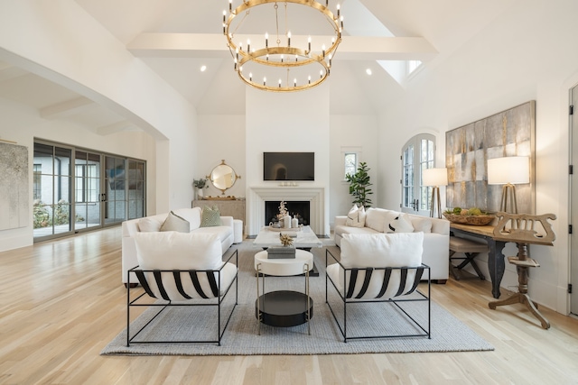 living room featuring high vaulted ceiling, light hardwood / wood-style floors, and beamed ceiling