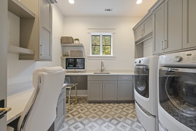 washroom with cabinets, sink, and washer and dryer