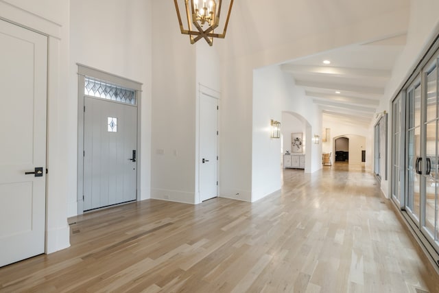 entrance foyer featuring light hardwood / wood-style floors and lofted ceiling with beams