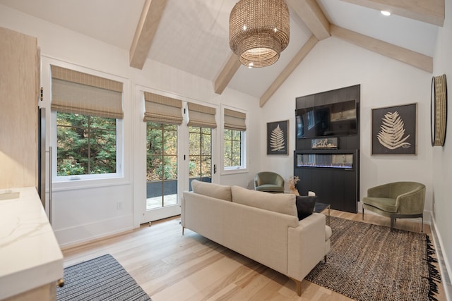 living room with light hardwood / wood-style flooring, french doors, vaulted ceiling with beams, and plenty of natural light