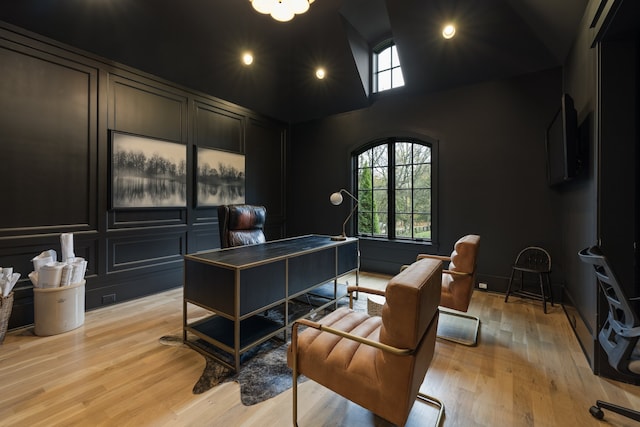 home office with high vaulted ceiling and light wood-type flooring