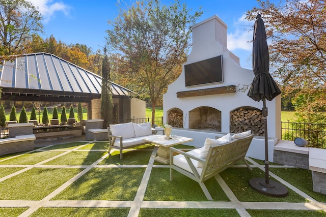 view of patio / terrace featuring a gazebo and an outdoor living space with a fireplace