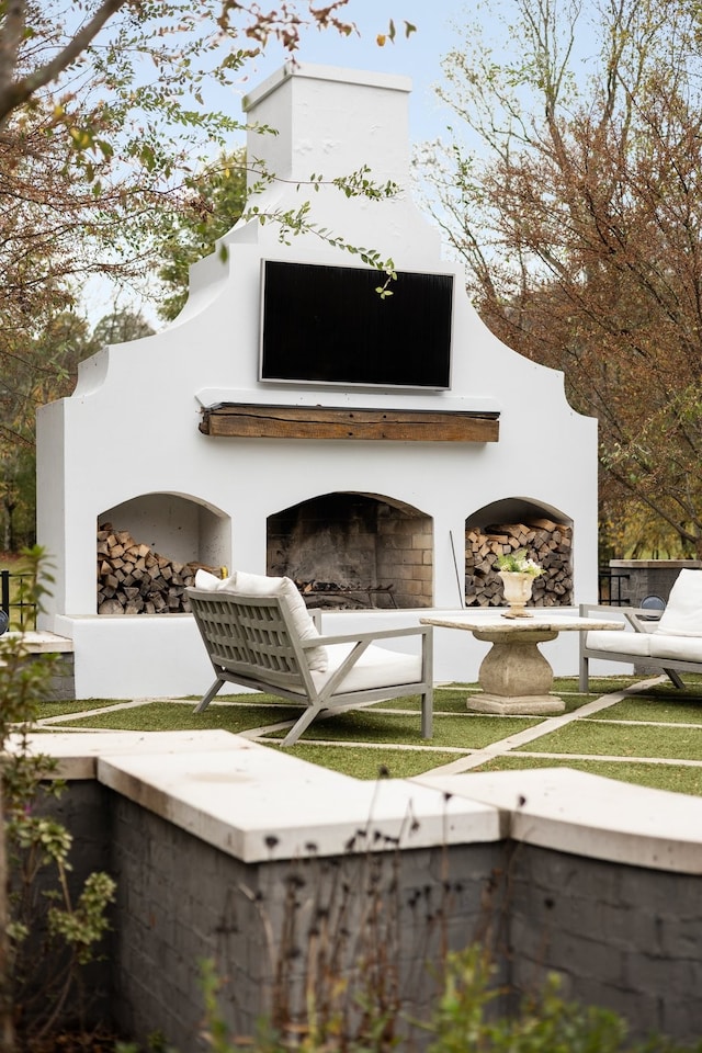 view of outdoor structure with exterior fireplace