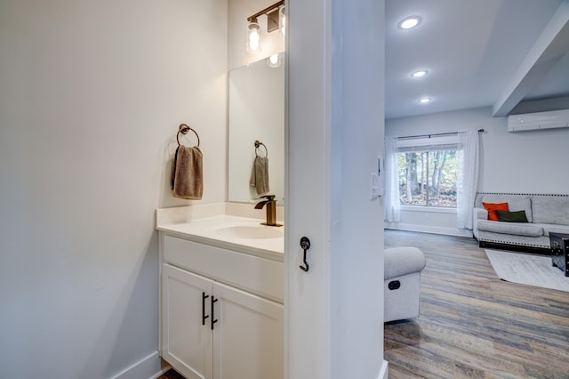 bathroom featuring a wall unit AC, wood-type flooring, and vanity