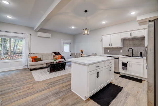 kitchen featuring white cabinetry, stainless steel appliances, sink, and a wall mounted air conditioner