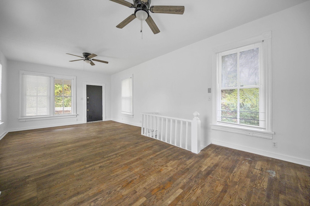 unfurnished room with ceiling fan and dark wood-type flooring