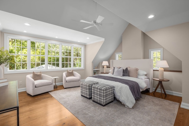 bedroom featuring hardwood / wood-style flooring, ceiling fan, and multiple windows