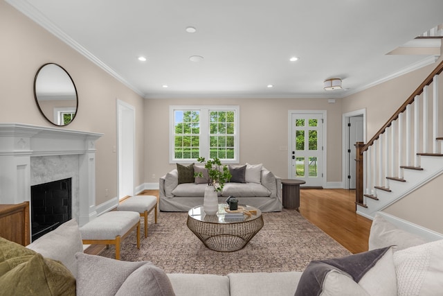 living room with a fireplace, crown molding, and light hardwood / wood-style flooring